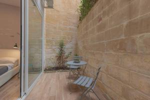 a room with a table and chairs and a brick wall at Sliema - 2 mins from the Beach in Sliema