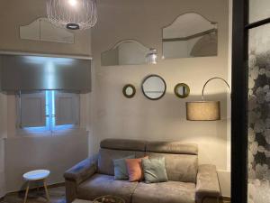 a living room with a couch and mirrors on the wall at Sliema - 2 mins from the Beach in Sliema