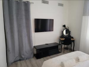 1 dormitorio con 1 cama, TV y escritorio en 1 Chambre paisible à La Trinité proche de Nice et Monaco, en La Trinité