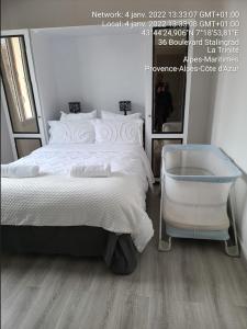 a bedroom with a white bed and a mirror at 1 Chambre paisible à La Trinité proche de Nice et Monaco in La Trinité