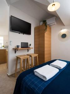 a bedroom with a blue bed with a tv on the wall at Ovadia Somech #6 in Jerusalem