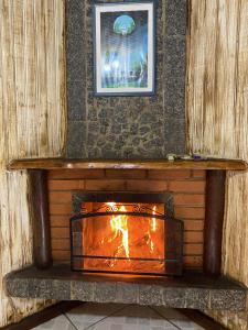 a fireplace in a wall with a fire in it at Pousada Chalés Canto do Rio in Visconde De Maua