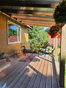 a wooden deck with two chairs and a bench at Atpūta namiņā pie jūras Skujiņas in Lembuži