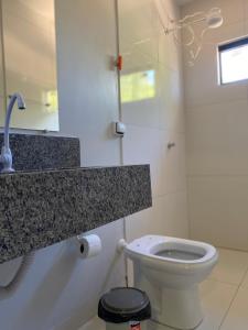 a bathroom with a toilet and a counter top at Pousada Amanhecer no Jalapão in São Félix do Tocantins