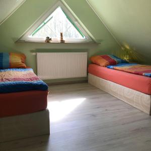 Zimmer im Dachgeschoss mit 2 Betten und einem Fenster in der Unterkunft Ferienhaus Binz in Binz