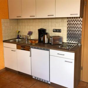 ビンツにあるFerienhaus-Binzの白いキャビネットとシンク付きのキッチン