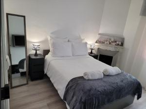 a bedroom with a large white bed and a mirror at 1 Chambre paisible à La Trinité proche de Nice et Monaco in La Trinité