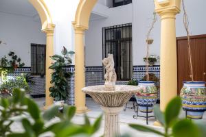 une fontaine au milieu d'une cour avec deux vases dans l'établissement Precioso Loft en Centro Histórico de Córdoba., à Cordoue