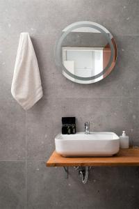 ein Badezimmer mit einem weißen Waschbecken und einem Spiegel in der Unterkunft Galini Mare in Agia Galini