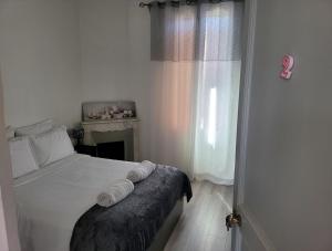a bedroom with a bed with white sheets and a fireplace at 1 Chambre paisible à La Trinité proche de Nice et Monaco in La Trinité