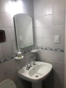 Baño blanco con lavabo y espejo en departamento centrico y moderno en Corrientes
