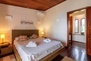 ein Schlafzimmer mit einem Bett mit zwei Handtüchern darauf in der Unterkunft Luna Villa Private Beach in Nea Iraklia