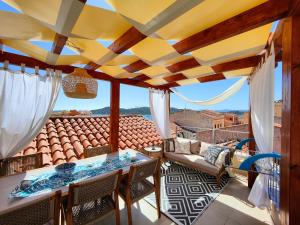 un patio con tavolo e sedie sul balcone. di Capricci di Vento - Design Guest House a La Maddalena