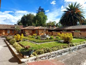 un jardín frente a una casa en Hosteria Rumipamba De Las Rosas, en San Miguel de Salcedo