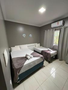 - une chambre avec 2 lits et une fenêtre dans l'établissement Pousada Praia Bela, à Maragogi
