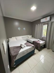 a bedroom with two beds and a window at Pousada Praia Bela in Maragogi