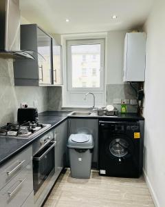 een keuken met een wastafel en een wasmachine bij SIMPLE 2BED FLAT IN EDINBURGH. in Edinburgh