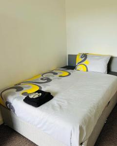 a bedroom with a bed with yellow and white sheets at SIMPLE 2BED FLAT IN EDINBURGH. in Edinburgh