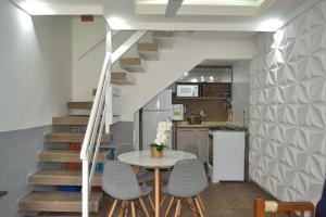 a kitchen and staircase with a table and chairs at temporada praia do forte cabo frio in Cabo Frio