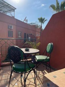 een tafel en stoelen op een balkon met een tafel en stoelen bij Riad Charlie in Marrakesh