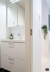 una cocina con armarios blancos y fregadero en Spacious and cozy, well equipped, 2 bedroom apartment in great location, en Tampere