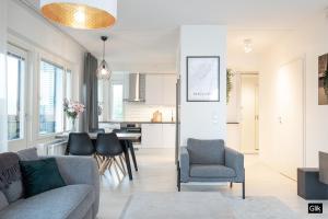 een woonkamer met een bank, stoelen en een tafel bij Spacious and cozy, well equipped, 2 bedroom apartment in great location in Tampere