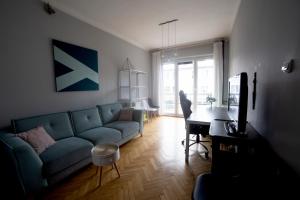 a living room with a blue couch and a table at Złota Centrum in Kielce