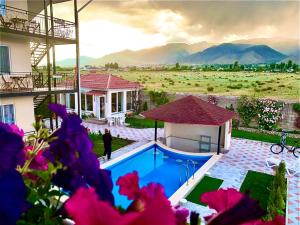 uma villa com piscina em frente a uma casa em Guest House “Aura” em Cholpon-Ata