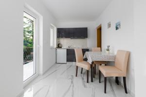 Apartments Melita في كريكفينيسا: مطبخ وغرفة طعام مع طاولة وكراسي