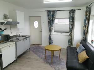 a kitchen and living room with a couch and a table at Comfortable apartment, 10min Airport in Stavanger