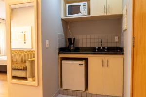 a small kitchen with a sink and a microwave at 360 Saint Charbel - Apartamentos mobiliados in Sao Paulo