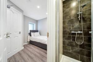 baño pequeño con ducha y cama en HillTop View 'Sleeping 5 guests', en Derry Londonderry