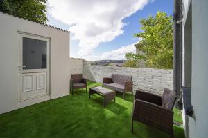 a patio with chairs and a door and grass at HillTop View 'Sleeping 5 guests' in Derry Londonderry