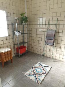 a bathroom with a tiled floor with a rug on the floor at Comfortable apartment, 10min Airport in Stavanger
