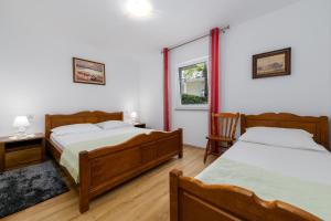 sypialnia z 2 łóżkami i oknem w obiekcie Apartments Melita w Crikvenicy