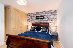 a bedroom with a bed and a brick wall at Lakeside Reach in Doncaster