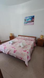 a bedroom with a pink bed with a pink blanket at La Villetta sul mare in Marina di Modica