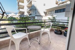 a balcony with two chairs and a table on a balcony at Hamaretou Apartment in Sparta