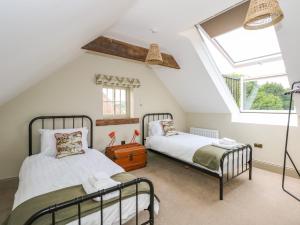 two beds in a attic bedroom with a skylight at The Stable at Warren House in Market Rasen