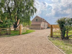 a driveway with a fence and a barn at The Stable at Warren House in Market Rasen