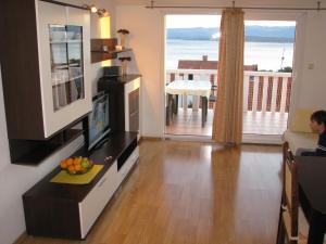 a living room with a television and a view of the ocean at Apartments & Rooms Pierino in Bol