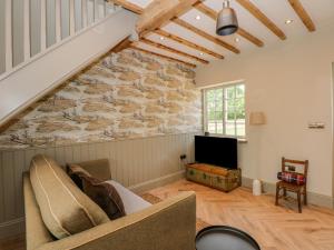 a living room with a stone wall at The Hayloft at Warren House in Market Rasen