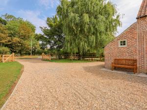 a gravel driveway with a bench next to a brick building at The Hayloft at Warren House in Market Rasen