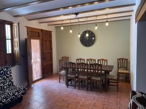 貝萊斯布蘭科的住宿－Casas Demi verhuurhuis，一间带桌椅和时钟的用餐室