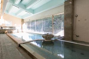 una piscina con una fuente en una habitación grande en Sansuikan Kawayu Midoriya en Hongu