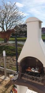 a pizza oven with a horse behind a fence at Domki Przy Pogodnej in Ustronie Morskie