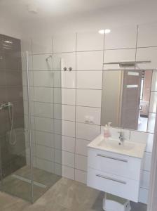 a bathroom with a shower and a sink and a mirror at Domki Przy Pogodnej in Ustronie Morskie