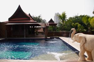 an elephant statue next to a swimming pool at Inrawadee Resort in Jomtien Beach