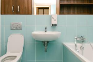 ein blau gefliestes Bad mit WC und Waschbecken in der Unterkunft Flora Cozy Apartment in Bratislava
