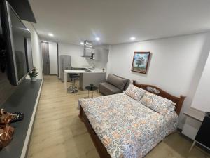 ein Wohnzimmer mit einem Bett und eine Küche in der Unterkunft Apartaestudio Galerias LOFT 2051 in Bogotá